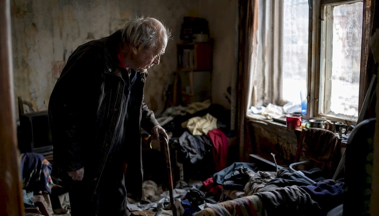 Homme âgé marchant lentement dans un couloir encombré d'obstacles
